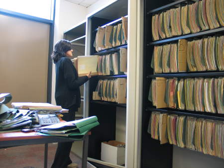 A receptionist helps to organise patient files